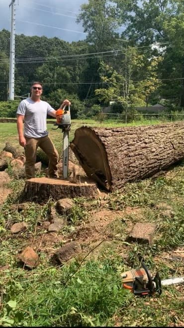 Joseph, the next generation of Moore's, beside a large cut tree trunk